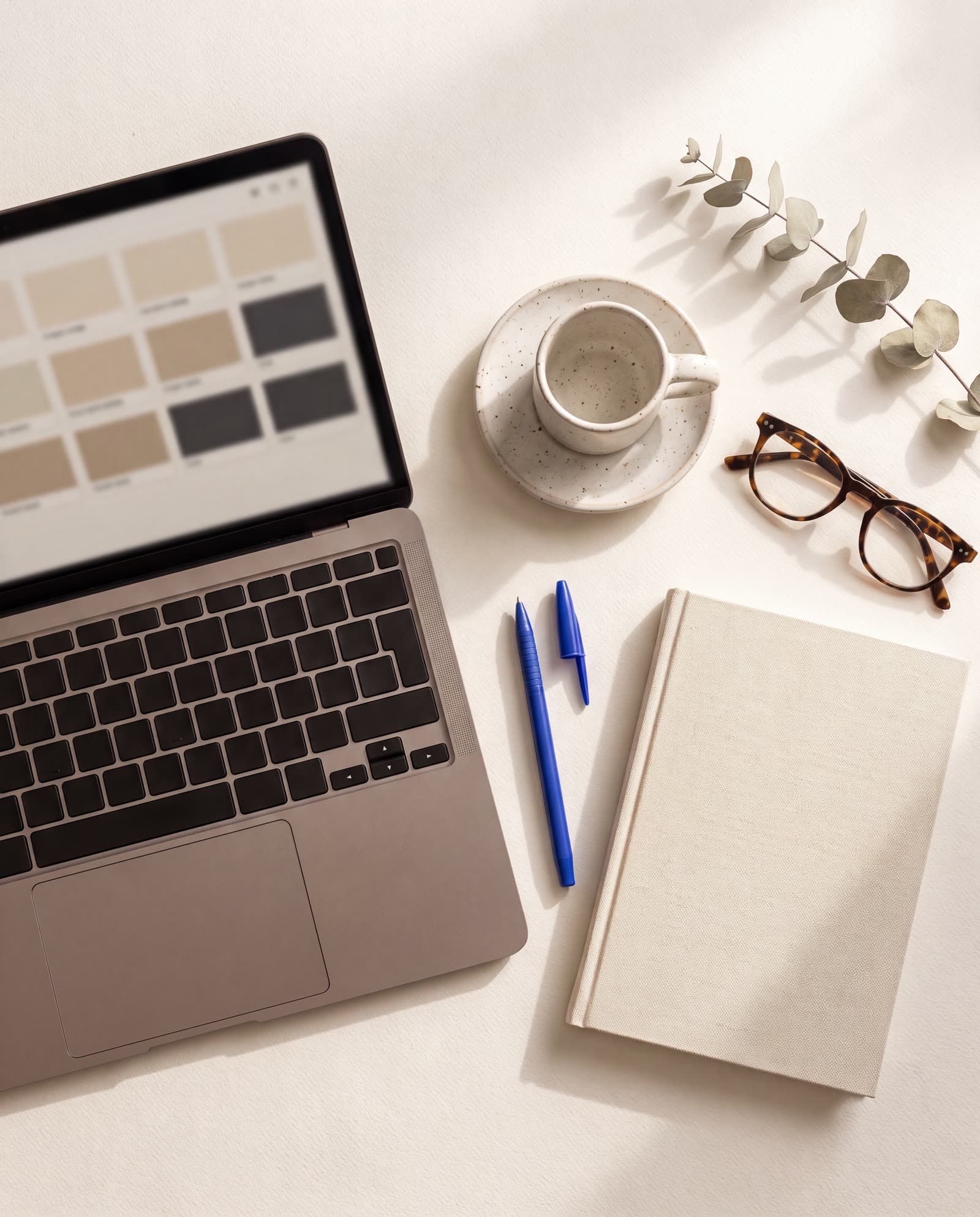 Bureau clair avec ordinateur, carnet et stylo bleu